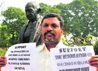 Lok Sabha member Thol Thirumavalavan holds placards outside Parliament in New Delhi.