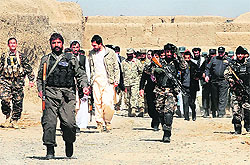 An Afghan delegation walks with locals after a gathering for a memorial ceremony at a mosque in Kandahar province on Tuesday