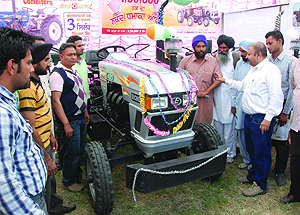 Farmers enquire about the technical details of a tractor at a stall put up at the Kisan Mela held at PAU Regional Research Centre in Bathinda on Wednesday