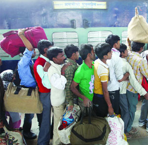 Passengers queue up to board a train at New Delhi Railway Station on Wednesday.  