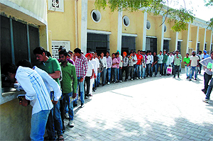 Students queue up outside a counter at the Government Rajindra College, to collect their roll numbers for the upcoming exams, in Bathinda on Thursday. 