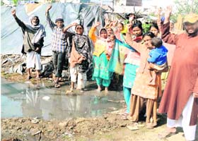 Residents of Ahbab Nagar hold a protest against the accumulation of sewage in front of their houses in Haridwar on Thursday