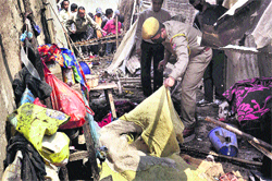 Police personnel inspect the blast site in Imphal 
