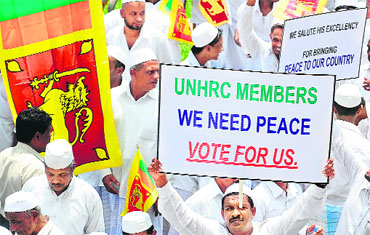 Government supporters hold placards and Sri Lankan flags during a protest in Colombo on Thursday. 