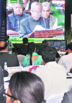 Industrialists watch Finance Minister Pranab Mukherjee presenting the fiscal 2013 budget on TV screens at CII in New Delhi on Friday. 
