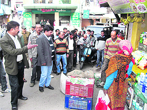 Executive officer Rohtash Sharma asks shopkeepers to remove goods from the land of the Municipal Council as part of an anti-encroachment drive in Mussoorie on Friday.