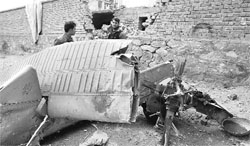 Afghan policemen stand near wreckage of a crashed helicopter at the site of the crash in Kabul on Friday. 