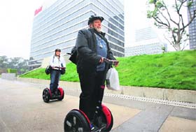 Apple co-founder Steve Wozniak carries the new third generation iPad that he just purchased as he and his wife Janet (L) ride their personal Segways to their hotel, after waiting in line overnight with customers to purchase the tablet at the Apple Store in Los Angeles, California on Friday