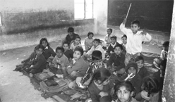 Most of the government schools still lack basic amenities like desks, chairs, toilets and teaching aids.