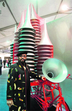 Wearing motifs of his paintings on a self-designed jacket, Paresh Maity stands in front of his art work