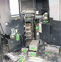 Parts of an ATM lie scattered in the booth