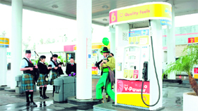 A group of Irishmen celebrating St Patrick's Day hide from the rain at a Canoga park gas station in Los Angeles, California on Saturday. Recent jumps in fuel prices are hurtful to the global economic recovery.