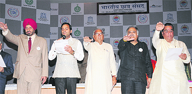 Chief Minister Bhupinder Singh Hooda (centre) administers students a pledge to make the democratic system better on the concluding day of Indian Student Parliament at Kurukshetra University on Sunday.