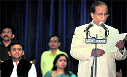 Samajwadi Party leader Mohammad Azam Khan takes oath as a Cabinet minister in Lucknow on Sunday. Uttar Pradesh Chief Minister Akhilesh Yadav is also seen