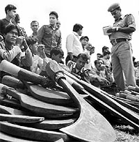 A policeman interrogates 75 Bangladesh nationals after rounding them up in Rajyarani Express