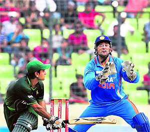 MS Dhoni (R) tries to catch the ball as Pakistans Mohd Hafeez plays a shot during their crucial Asia Cup ODI at the Sher-e-Bangla National Stadium in Dhaka on Sunday. India won the match by six wickets in what is their highest run chase in ODIs