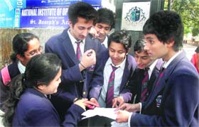 Students of Class X share last-minute notes before their examination in Dehradun on Monday