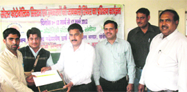 Additional Deputy Commissioner Ashok Bishnoi gives away a tool kit and a certificate to a trainee at a camp in Sonepat. 