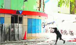 A protester throws a bicycle towards the Villa TV station office, owned by Jumhooree Party presidential candidate Gasim Ibrahim, during a protest in Male