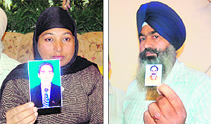 Family members of Hardayal Singh and Daljeet Singh show their photographs in Amritsar.