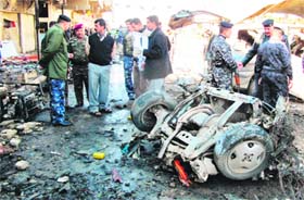 Policemen inspect the site of a car bomb explosion in Iraq on Tuesday