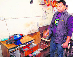 A shopkeeper shows the place from where cash and goods were stolen in Amritsar on Wednesday