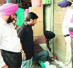 The MC house tax team seals a liqour vend on Sultanwind Road in Amritsar on Wednesday