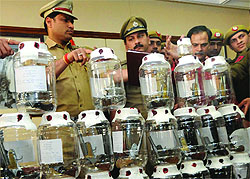 Officials of the Moti Nagar police station show the illegal pistols seized in New Delhi on Wednesday