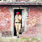 A cop comes out of the room in Shaheed Bhagat Singh Nagar on the Pakhowal road in Ludhiana. 