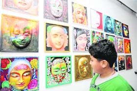 A boy watches masks at an exhibition in Dehradun on Thursday