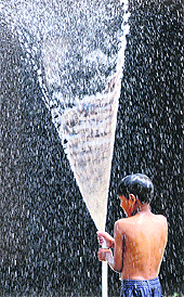 A child plays with a water pipe in Karnal. 