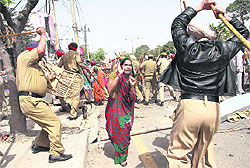 A jhuggi dweller being canecharged by the police