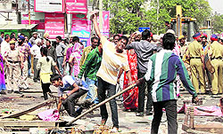 A protester pelts the police with bricks during a demolition drive at Gujral Nagar in Jalandhar on Thursday