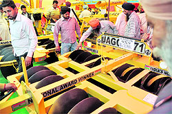 Farmers examine new farm machines put on display on the second day of Kisan Mela at the PAU in Ludhiana on Thursday