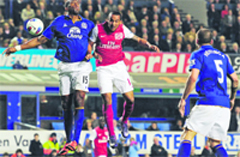 Arsenal's Theo Walcott (2nd L) vies with Everton's Sylvain Distin (L) during their match at Goodison Park in Liverpool