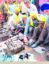 Members of the Shaheed Bhagat Singh Welfare Society polish shoes of cobblers on the Martyrdom Day of Bhagat Singh, Sukhdev and Rajguru in Amritsar on Friday.