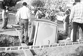 A car that fell into an open sewerage at the Kumbra light point on the road separating Phases 7 and 8 in Mohali on Friday.