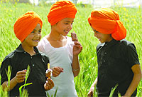 Remembering Bhagat Singh: Children wearing turbans of the martyrs favourite colour enjoy ice-creams in a field in Nawanshahr on Friday
