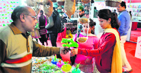 Girls buy decorative items at a stall during a trade fair at Kala Kendra in Jammu.