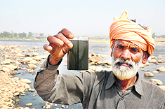 A local resident showing the polluted water taken from the river near Bhagwati Nagar in Jammu.