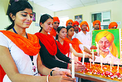 Students of St Soldier School light candles to pay tribute to Shaheed Bhagat Singh in Jalandhar on Friday