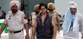 The injured jail inmate (extreme right) comes out of the Civil Hospital in Bathinda after getting treatment on Saturday.