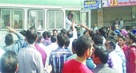 Protesting shopkeepers stop a bus at Shahkot on Saturday.