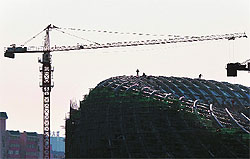 Workers stand on a partially completed building in Beijing on Sunday. China's central bank chief said conditions were ripe to liberalise interest rates, a move analysts say would boost domestic demand as the nation's exports are hit by overseas turmoil