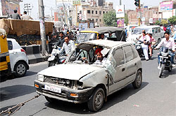 A man steers his run-down car as it is towed away probably to a garage for repair in Bathinda