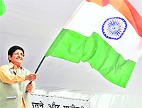Kiran Bedi waves the Tricolour during Anna Hazare's day-long fast near Parliament House in New Delhi on Sunday.