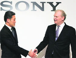 Sony's incoming CEO Kazuo Hirai (L) and current CEO Howard Stringer shake hands at a news conference in Tokyo in this February file photo. The biggest challenge facing Hirai will be how to bridge a divide in the company between the fundamentalists" and "new-agers"