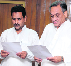 Chief Minister Vijay Bahuguna administers the oath of office to Furqan Ahmed at Vidhan Sabha in Dehradun on Monday.