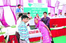 A woman picks up a slip from a drum during the draw of lots for residential plots at Alpha International City in Fatehabad on Monday