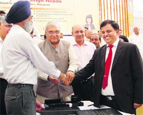 Top bureaucrat SS Dhillon and Kumar Keshav of the DMRC shake hands after signing an agreement for the extension of Metro in Faridabad on Monday as Chief Minister Bhupinder Singh Hooda looks on
